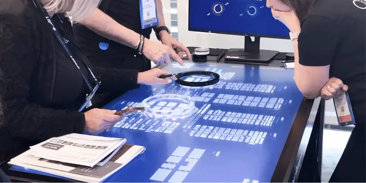Exhibitors using the magnify ring on the ISE floor plan table